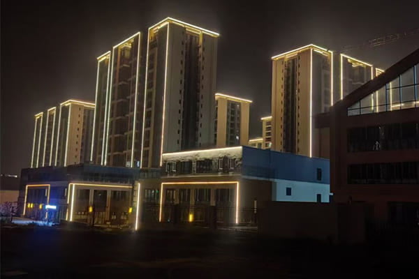 A beautifully lit modern building facade at dusk, showcasing compliant lighting that avoids light spill into the sky.